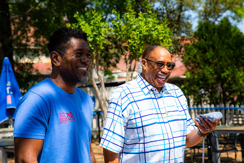 Patient and doctor outside enjoying a game of cornhole