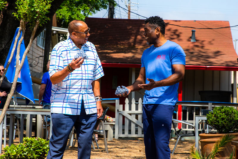 Patient and Doctor outside enjoying a game of cornhole