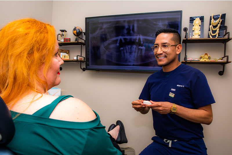 Doctor and Patient going over dental implant information while showing implant model